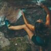 Ein symbolisches Bild für die Pflanze Maca: eine sportliche Frau klettert mit Energie und muskulösen Beinen in einer Felswand.